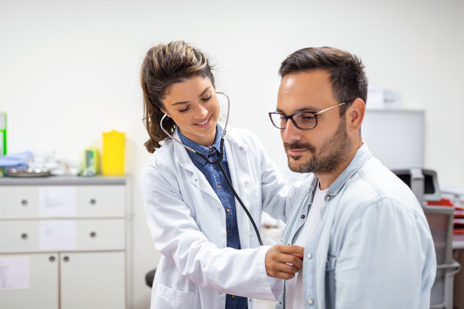 Médica da Clínica Higya ouvindo o coração de um paciente com estetoscópio